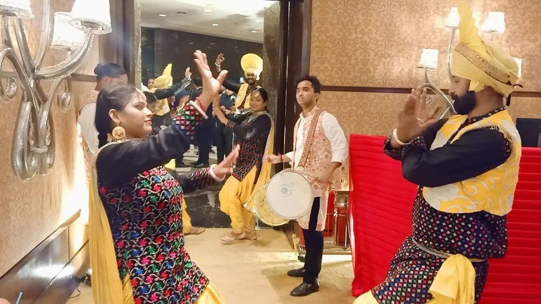 Bride making a choreographed entry surrounded by performers and decorative lighting